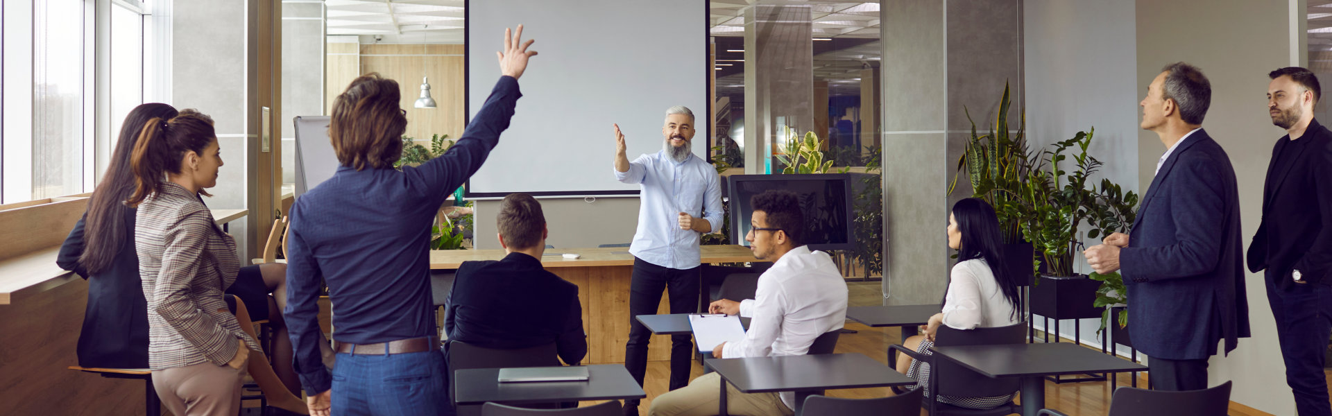 Group of adult students having class with business teacher in modern office